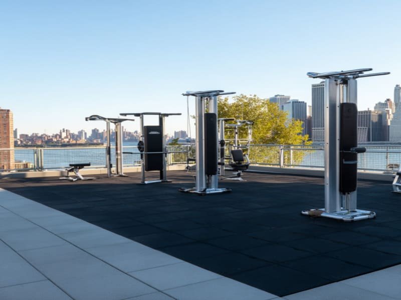 Een close-up van een hand die de textuur van een antislip rubberen bestrating voor buiten test.